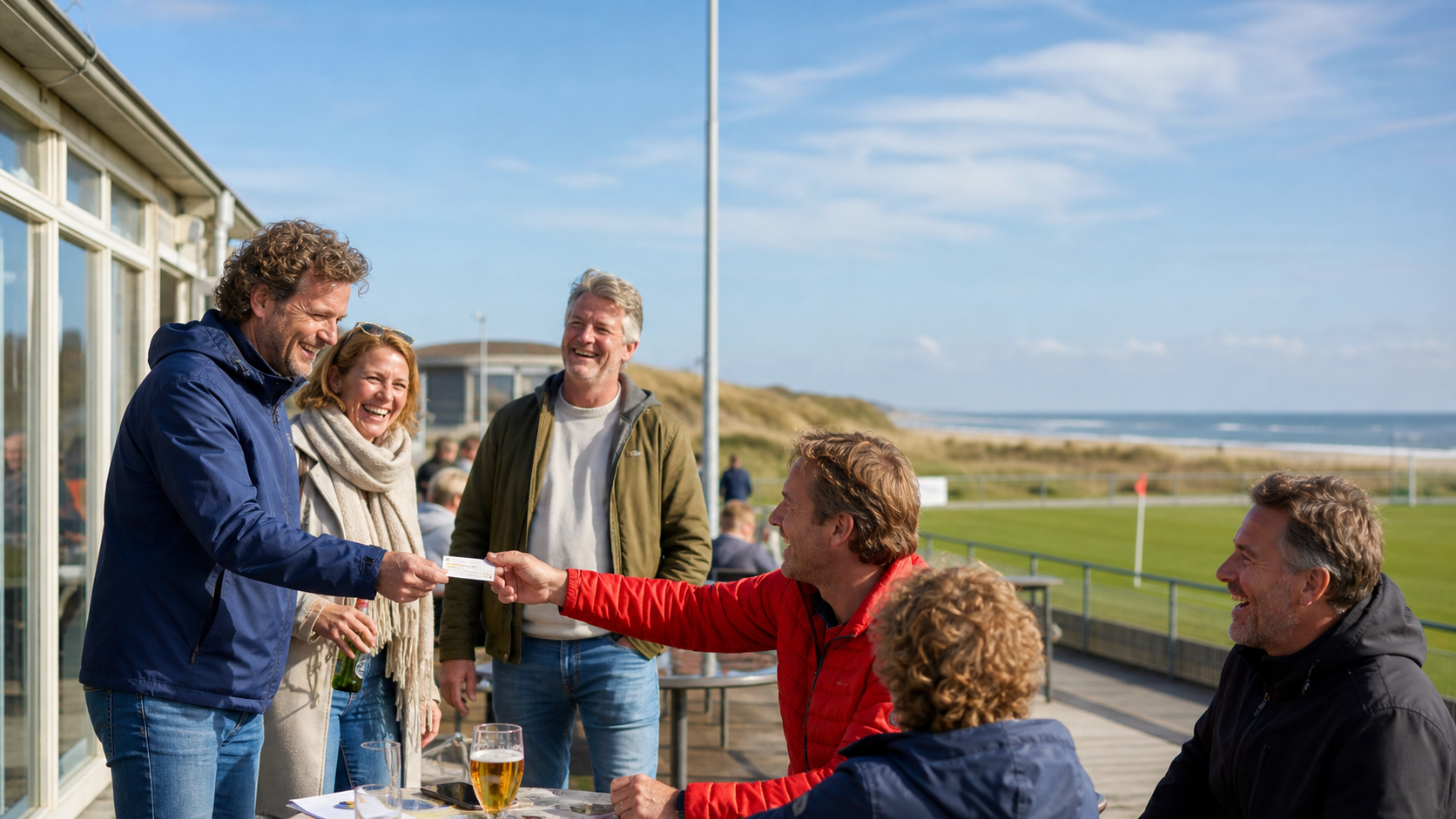 Vrienden ontvangen een lot op een zonnig terras naast het voetbalveld